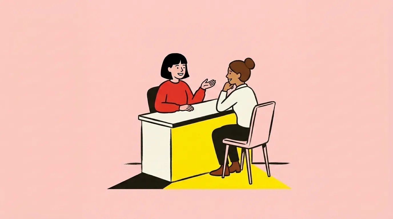 Two people sitting either side of a front desk, mid-conversation and relaxed