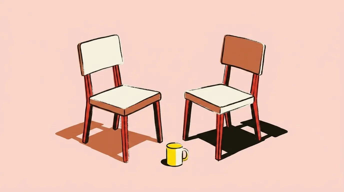 Two chairs turned toward each other with a mug between them