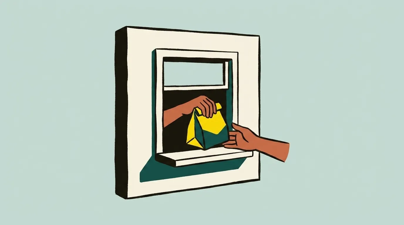A service window from outside, with two hands meeting across the sill, one passing a bag